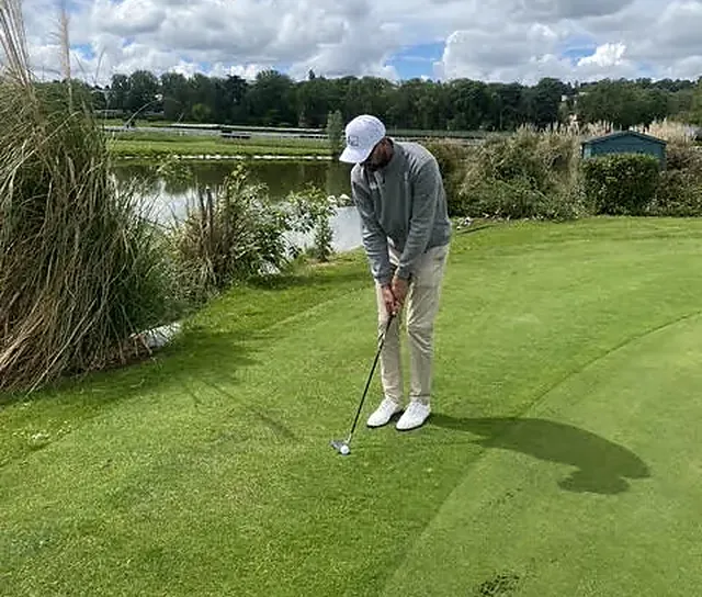 Alexis à l'adresse sur un green bordé d'eau