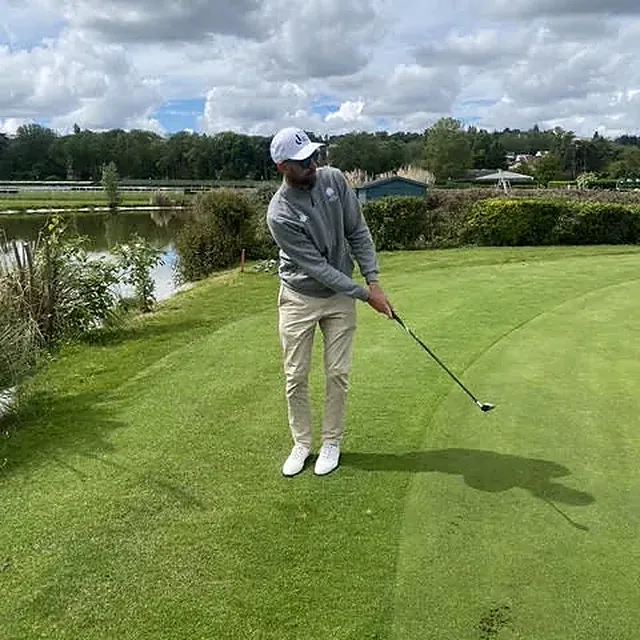 Alexis joue une approche au bord d'un plan d'eau